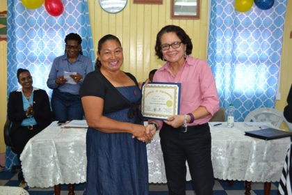 First Lady, Mrs. Sandra Granger presents one of the participants with her Certificate, signifying her successful completion of the Self Reliance and Success in Business Workshop. 