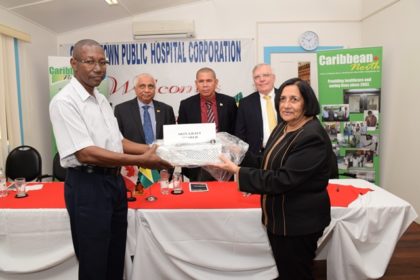 Pamela Harakh, cofounder of Caribbean North Charities Foundation Guyana, handing over the equipment to GPHC’s Chief Executive Officer (CEO), Allan Johnson.  Minister of Public Health, Dr. George Norton and Canadian High Commissioner to Guyana, Pierre Giroux look on.