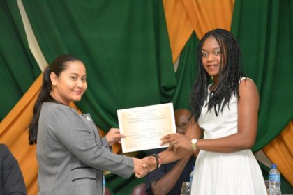 Ms. Adeti DeJesus, of the Office of the Presidential Advisor on Youth Empowerment presents a certificate to one of the participants at the graduation ceremony