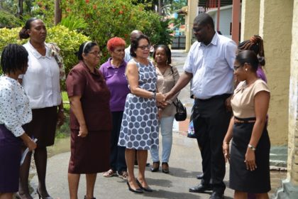  First Lady, Mrs. Sandra Granger chats with Mr. Whentworth Tanner, Director of Social Services at the Ministry of Social Protection, while care-givers, matrons and other persons look on. 