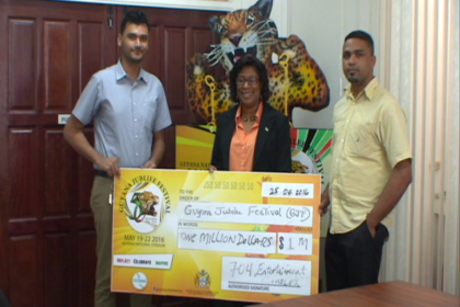 Minister of Public Telecommunications Catherine Hughes receives cheque from 704 Sports Bar representatives