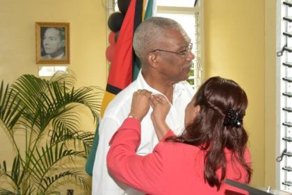 Minister within the Ministry of Communities, Ms. Dawn Hastings-Williams pins a special pin on President Granger, as a token of appreciation from the People's National Congress. 
