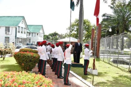 Ambassador Christensen stands at attention as members of the Guyana Defence Force hoist the National Flags of the two countries