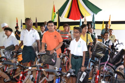 Minister of Social Cohesion, Ms. Amna Ally and some of the Region Four recipients of bicycles and backpacks interact after the ceremony