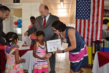 First Lady Mrs. Sandra Granger hands over a certificate to one of the youngest graduates. 