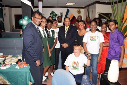 Prime Minister Moses Nagamootoo and Minister of Public Security Khemraj Ramjattan pose with staff at the Guyana exhibit during yesterday’s CARICOM Culture Day activity at the Ministry of Public Security.