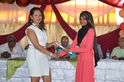 Trainer Ishranie Singh presenting a certificate to best student in Information Technology, Shazeema Nizamudin at the National Training Project for Youth Empowerment graduation ceremony at the Upper Corentyne Industrial Training Center