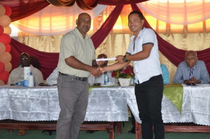 Mayor of Corriverton, Ganesh Gangadin presents a certificate to a graduate of the National Training Programme for Youth Empowerment under the Board of Industrial Training. The training was done at the Upper Corentyne Industrial Training Centre 