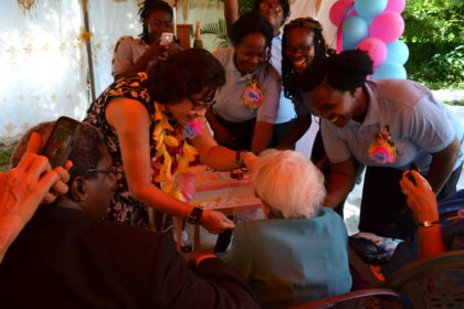  First Lady, Mrs. Sandra Granger gives Ms. Myrtle Fleming a piece of her birthday cake as care-givers at the Millicent Greaves Memorial Residence look on.  Ms. Fleming is celebrating her 95th birthday today