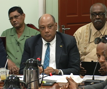 Minister of Natural Resources, Raphael Trotman at Parliamentary Sectoral Committee on Natural Resources. Behind him are Commissioner,  Guyana Forestry Commission (left) , James Singh and  Commissioner (ag) of the Guyana Geology and Mines Commission, Newell Dennison  