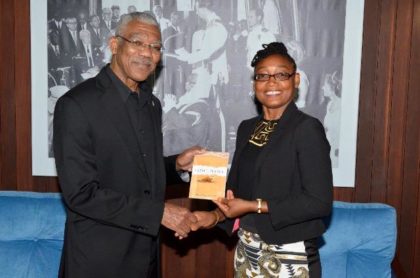 Ms. Marcia Shury hands over a copy of the book to President David Granger, earlier today at the Ministry of the Presidency.  