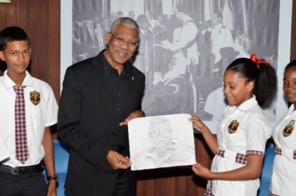 Fourteen years old Hannah Monroe hands over the portrait she drew with charcoal to President David Granger, earlier today at the Ministry of the Presidency.