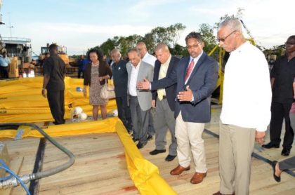 Chief Executive Officer of GAICO Construction and General Services Incorporated, Mr. Komal Singh, explains the operation of this apparatus to President David Granger, at the launch of the Oil Spill Response Services company.