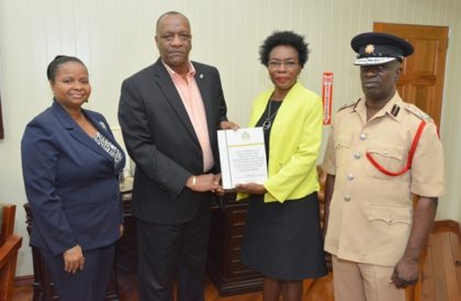 Minister of State, Mr. Joseph Harmon receives the report of the Commission of Inquiry into the deaths of the victims of the Hadfield Street Drop In Centre from Commissioner, Retired Colonel Windee Algernon(centre-right) . Minister of Social Protection, Ms. Volda Lawrence and Acting Chief Fire Officer, Mr. Winston McGregor (right) also received copies of the report. 