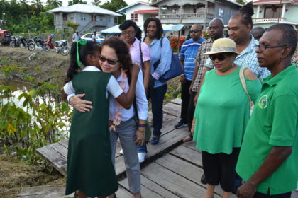 Mrs Granger receives a hug from a student on her arrival at the Arthurville Primary School, in Wakenaam, Essequibo Islands-West Demerara (Region 3)