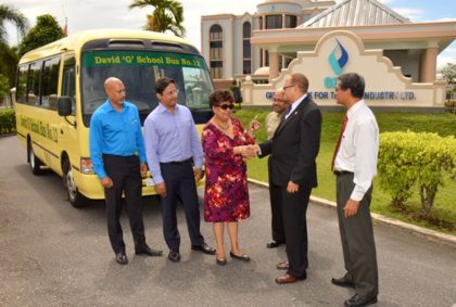 Minister Ally happily receives the key from Mr. Robin Stoby, Chairman of GBTI to the “David G” school bus, which was donated to President Granger Five Bs initiative by the Guyana Bank for Trade and Industry Ltd (GBTI) as the directors look on (L – R) Mr. Suresh Beharry, Director of GBTI and Edward B. Beharry Company, Mr. Anand Beharry Director of GBTI and Edward B. Beharry Company, Mr. Basil Mahadeo, Director of GBTI and Mr. John Tracey the Chief Executive Officer of GBTI.  