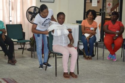 Two participants, demonstrate First Aid response for a broken arm by “Sling and a binder” 
