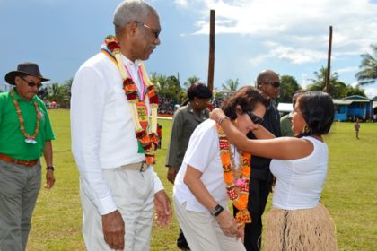 First Lady Mrs. Sandra Granger is garlanded by this young lady from Kamarang as President David Granger looks on.