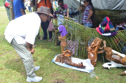 Minister of Indigenous Peoples' Affairs, Sydney Allicock examining some of the items on display at the Moruca expo 2016