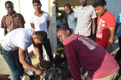 Some of the youths actively engaging in the Auto Mechanic class