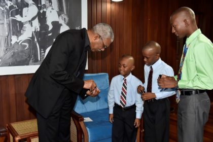 President David Granger giving the three brothers tokens, during their visit to the Ministry of the Presidency.