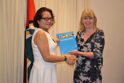 First Lady, Mrs. Sandra Granger receiving her copy of the Situation Analysis Report of Women and Children from UNICEF Representative to Guyana and Suriname, Ms. Marianne Flach.