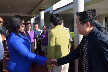 Minister within the Ministry of Public Health, Dr. Karen Cummings greets a members of the Chinese Vice-Ministerial delegation as they arrive at the Cheddi Jagan International Airport