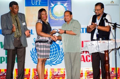 Prime Minister Moses Nagamootoo presents Appointment Certificate of Peace Ambassadorship to Jochebed Edghill in the presence of UPF Guyana Chapter National Chairman Haji Roshan Khan and General Secretary Rev. Ronald Mc Garrell
