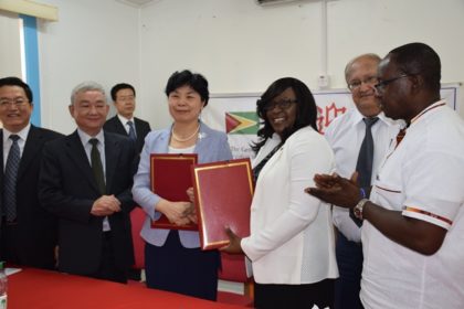 Minister within the Ministry of Public Health Dr. Karen Cummings and Vice Minister of National Health and Family Planning Commission of the People’s Republic of China exchange the signed certificates that covered  the gifts that had been handed over