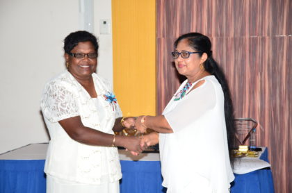 Mrs Sita Nagamootoo presenting a token of appreciation to Parbattie Rangall, Headmistress of Goed Fortuin Nursery. Rangall was one of several teachers who have attained 35 years of service and are still in the system.