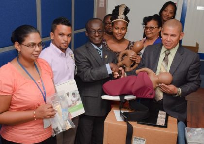 Minister of Public Health, Dr. George Norton receives donation of obstetrics equipment from PAHO/WHO Representative, Dr. Adu-Krow in the presence of Health officials