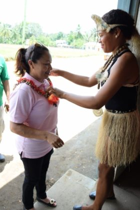 Minister in the Ministry of Communities, Dawn Hastings- Williams being garlanded by a young White Water resident upon her arrival to the village 