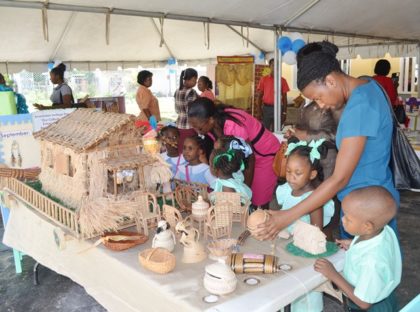 Children and teachers examining the corner displaying the indigenous culture at the exhibition to mark 40 years of development in Early Childhood/Nursery Education in Guyana 