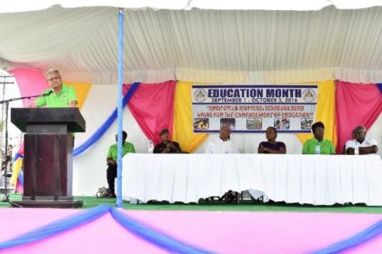 Minister of Education, Dr. Rupert Roopnaraine addressing the students. Seated at the head table from right: Chief Education Officer (ag) Mr. Marcel Hutson, Permanent Secretary, Ministry of Education, Ms. Delma Nedd, Minister within the Ministry of Education, Ms. Nicolette Henry and President David Granger. 