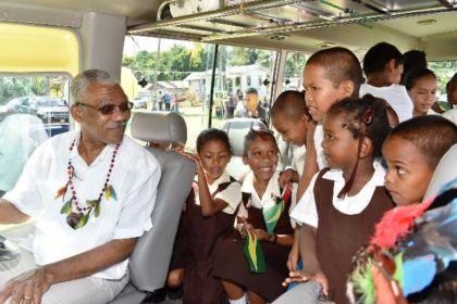 President David Granger takes the driver seat of the 'David G. No. 13' while the children get acquainted with their new ride to school