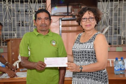 Toshao of Versina community receiving Jubilee grant from Minister within the Ministry of Indigenous Peoples’ Affairs Valerie Garrido-Lowe