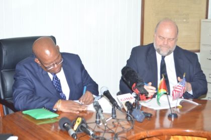 Hon . Winston Jordan Minister of Finance and Ambassador of the United States of America to Guyana, Perry Holloway signing the FATCA agreement at the Ministry of Finance, earlier today
