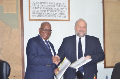 Hon. Winston Jordan Minister of Finance and Ambassador of the United States of America to Guyana, Perry Holloway displaying the  signed FATCA agreement at the Ministry of Finance, earlier today