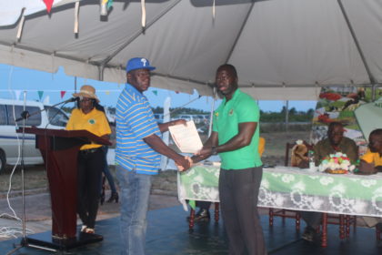 A farmer collecting his land lease from Deputy CEO of GKDA, Dr. Walrond Powered