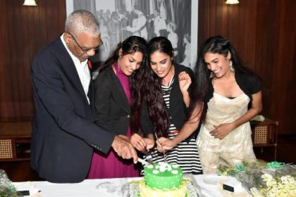 President David Granger sticks the birthday cake with Ms. Radha Mansaram, Ms. Rajshri Mansaram and Ms. Reenica Mansaram on their 22nd birthday.  