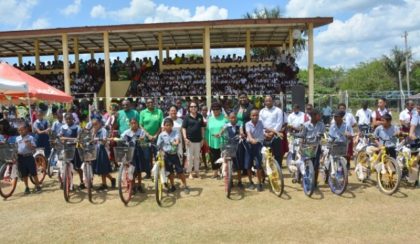  Students from several schools in Kwakwani display their brand new bicycles along with Minister of Social Cohesion, Ms. Amna Ally, First Lady, Mrs. Sandra Granger and representatives of Region Ten.