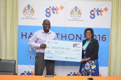 Justin Nedd, Chief Executive Officer of the Guyana Telephone and Telegraph Company (sponsor of the Hackathon) handing over cheque to Minister of Public Telecommunications, Catherine Hughes